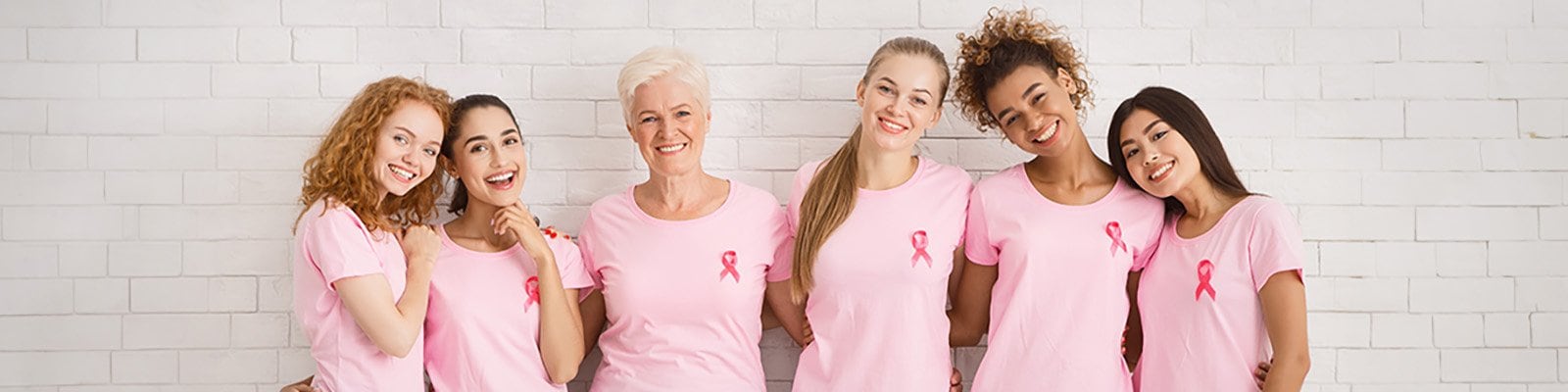 ladies of varied ages dressed in pink wearing pink ribbons