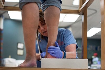 therapist evaluating patient's foot