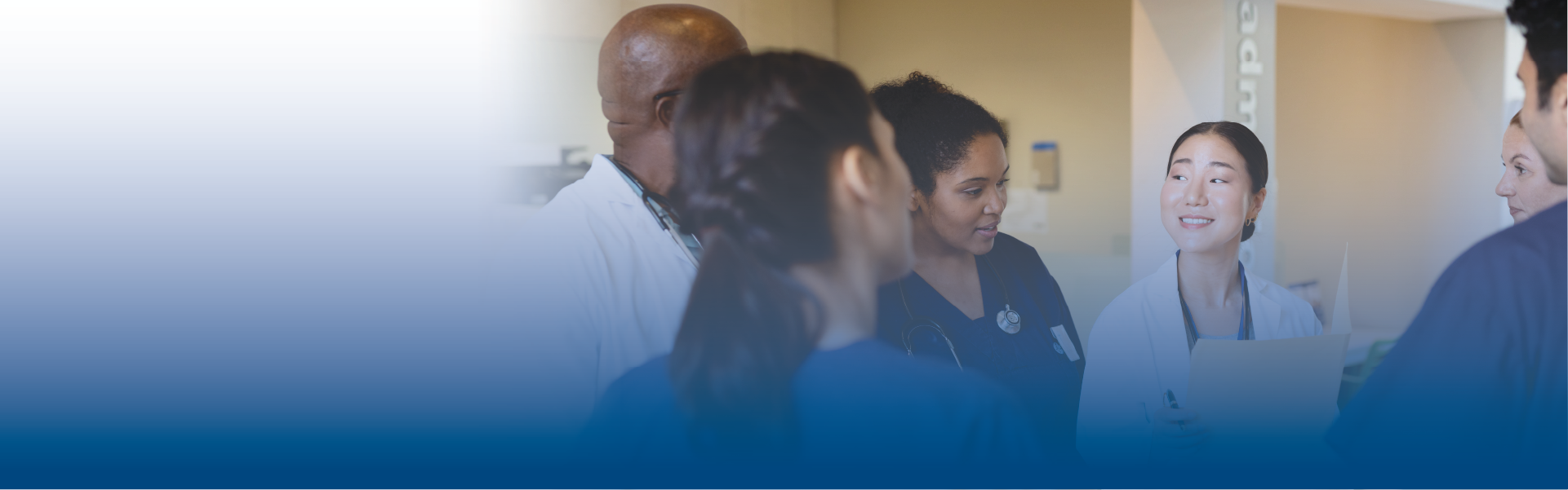 a group of health care providers talks in a hospital hallway