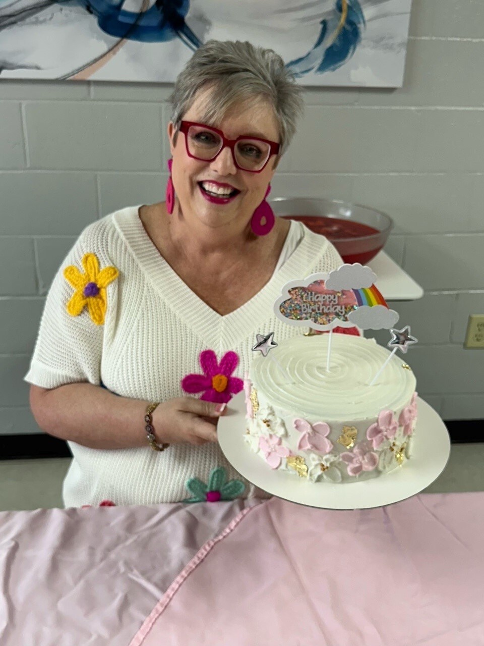 Meg Deaton poses with a floral birthday cake