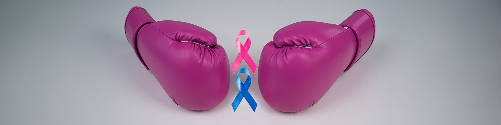 Pink boxing gloves with pink breast cancer awareness ribbon and blue colon cancer awareness ribbon