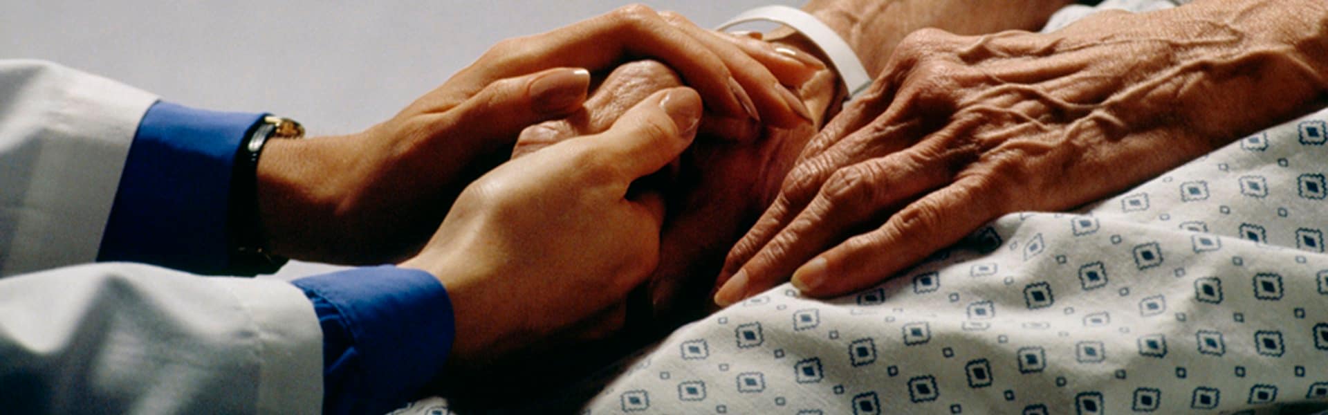 caregiver holding patient's hand