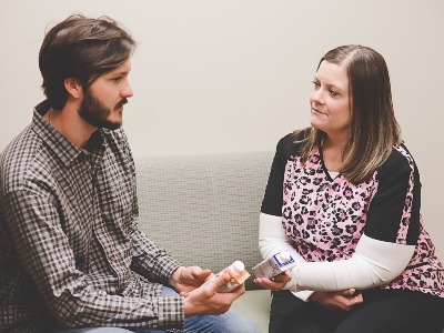 Cancer Care dietitian reviews nutrition labels with young man.