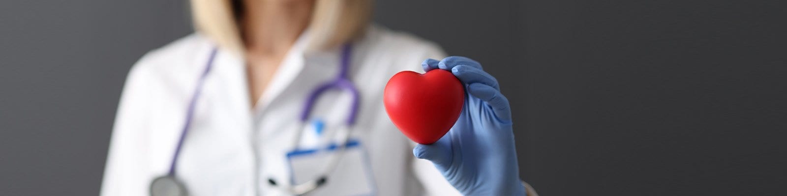 a doctor holding up a red heart